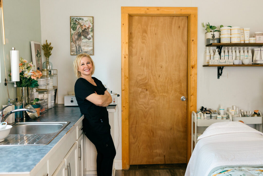 Branding photo of spa owner smiling while standing in her workspace