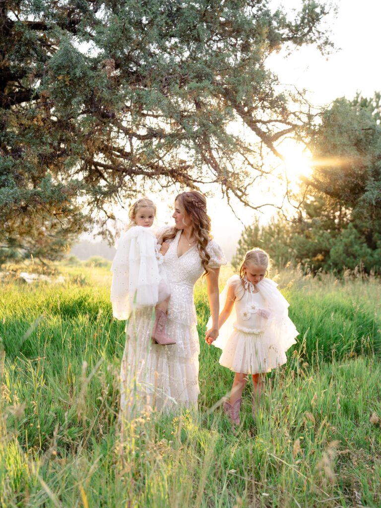 Motherhood session of Amara and her girls outside, twirling in capes with golden sunset light.