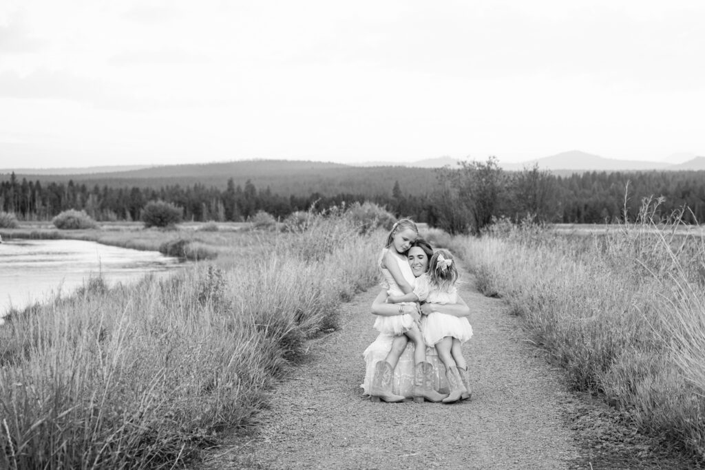 Moody B&W session outdoors, featuring Amara and her girls in dresses and capes.