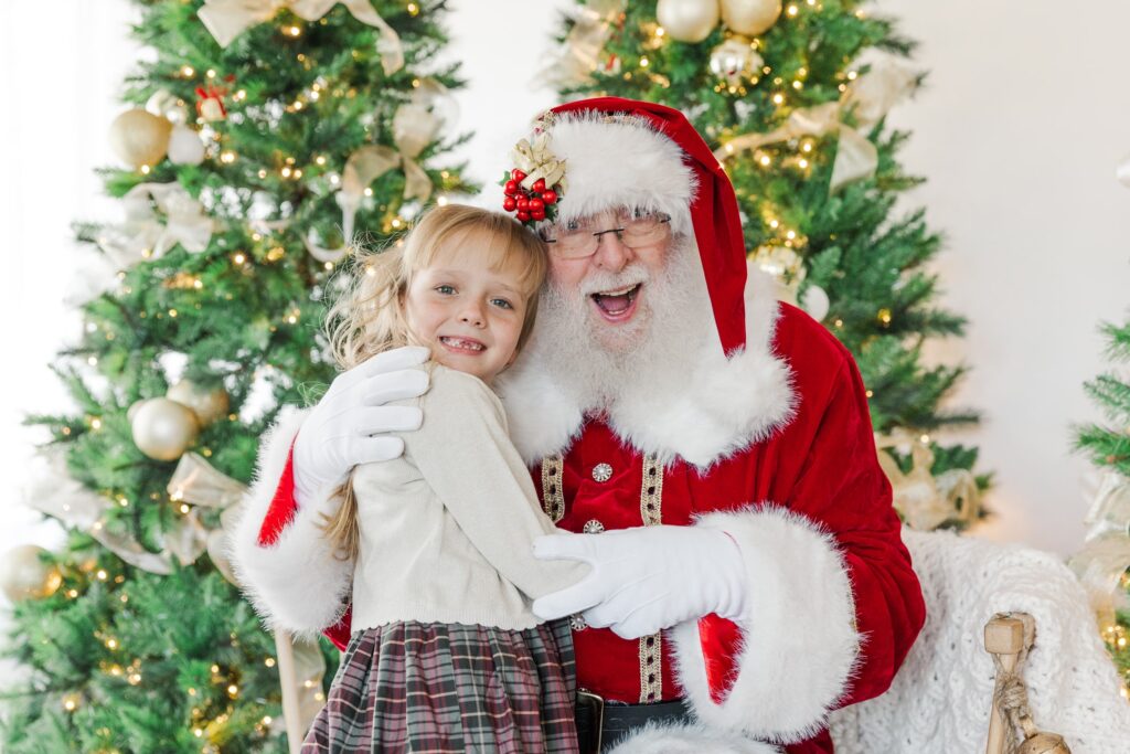 Santa with a girl posing for Holiday Kids Portrait.