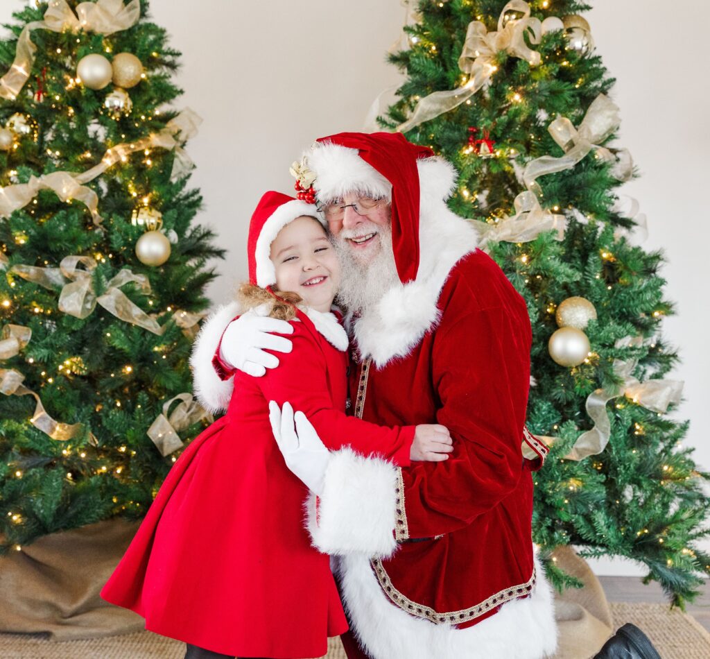 Little girl hugging Santa during Holiday Kids Portrait  session.