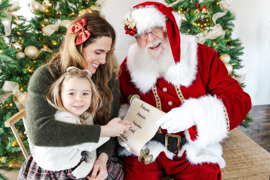 Child and mom sitting with Santa during a Holiday Kids Portrait session
