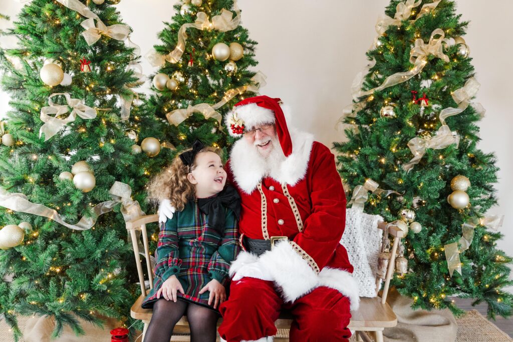 Santa posing with a kid in a calm, festive photography session.