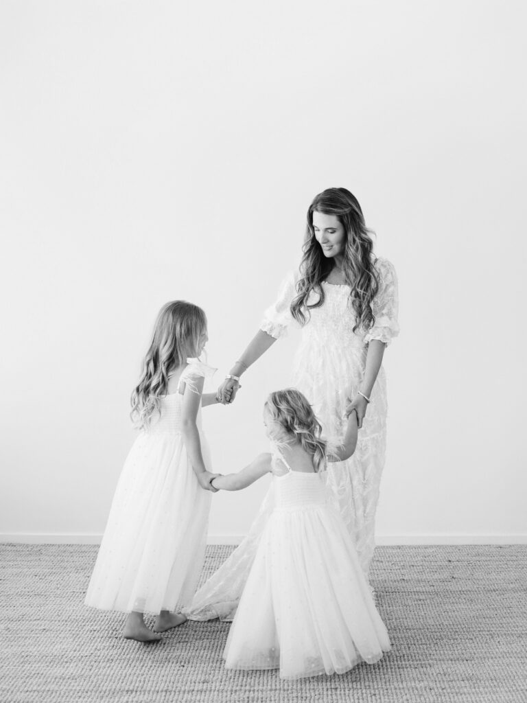 Black and white session of Amara and her girls indoors, capturing intimate family connection.