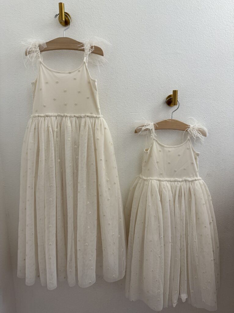 Behind the scenes of wardrobe featuring the girls’ soft and playful dresses.