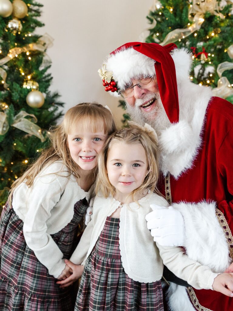 Kids meeting Santa in a cozy holiday studio setting.