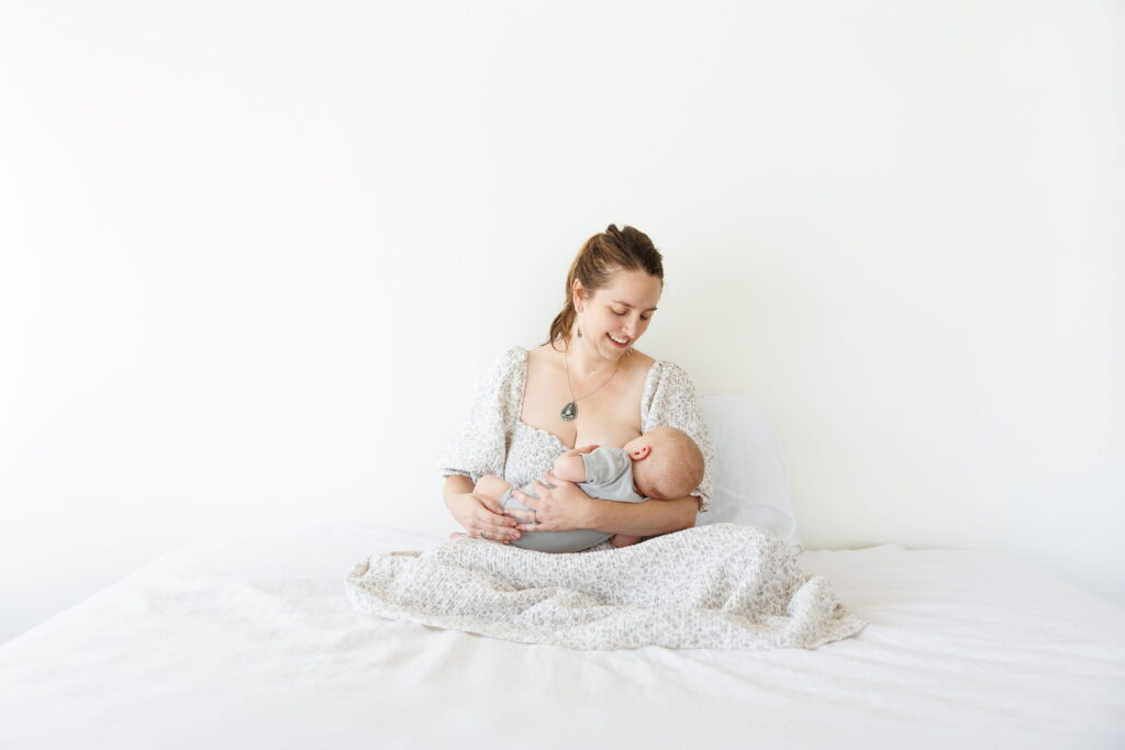 Mother holding her young child during an intimate newborn photography session