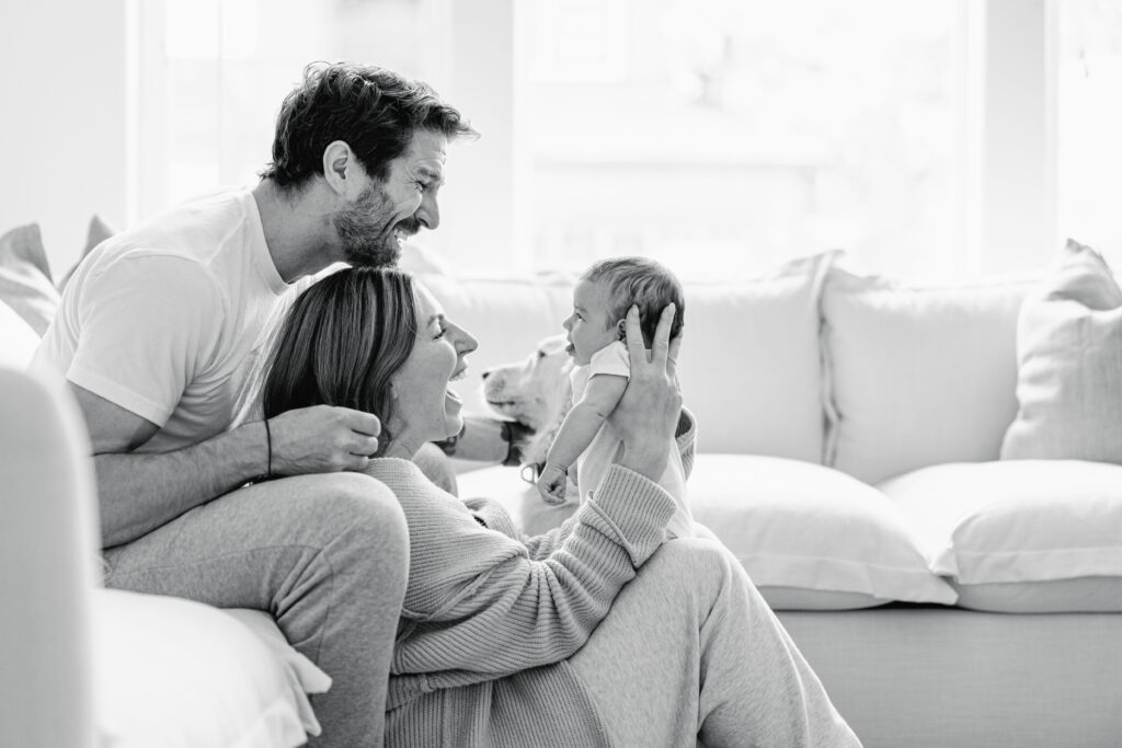 Family relaxing together with their baby during a lifestyle newborn session.