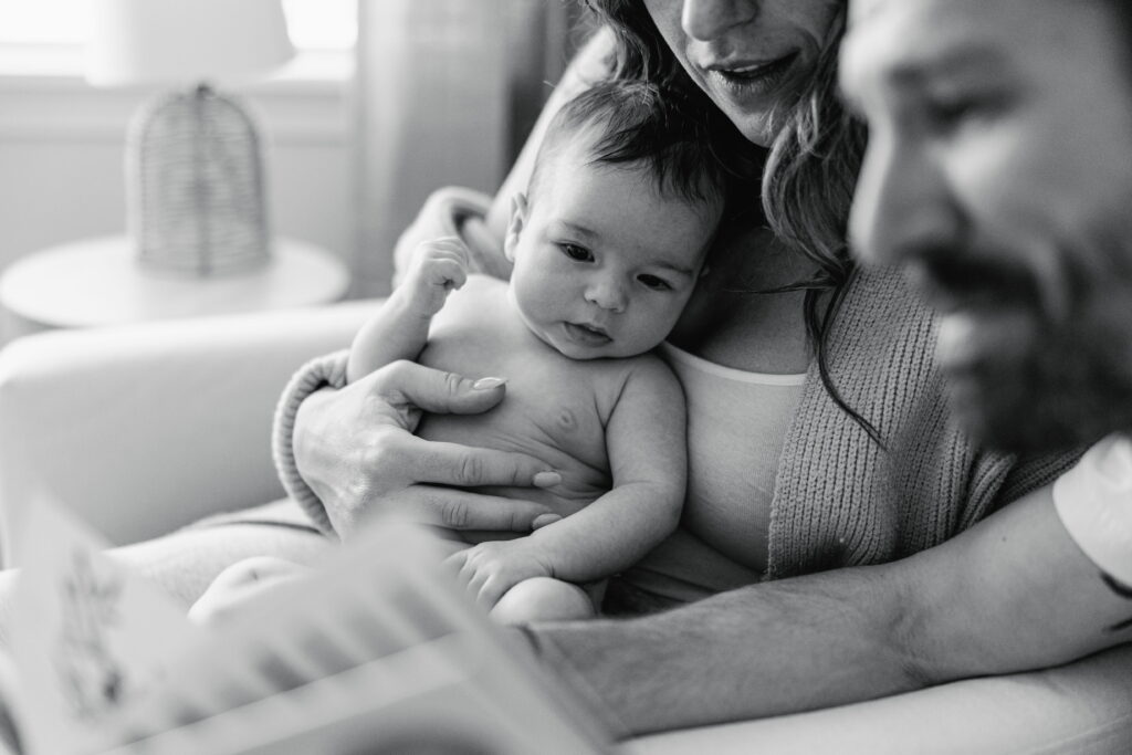 Parents holding their newborn close in a calm, uncluttered space.