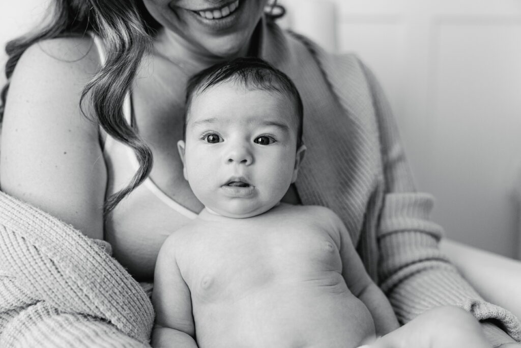 Mother holding her newborn close during a quiet morning at home