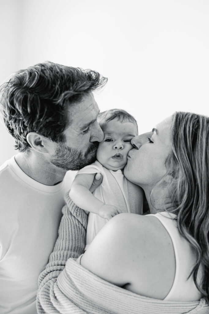 Parents sharing a tender moment with their newborn in their home.