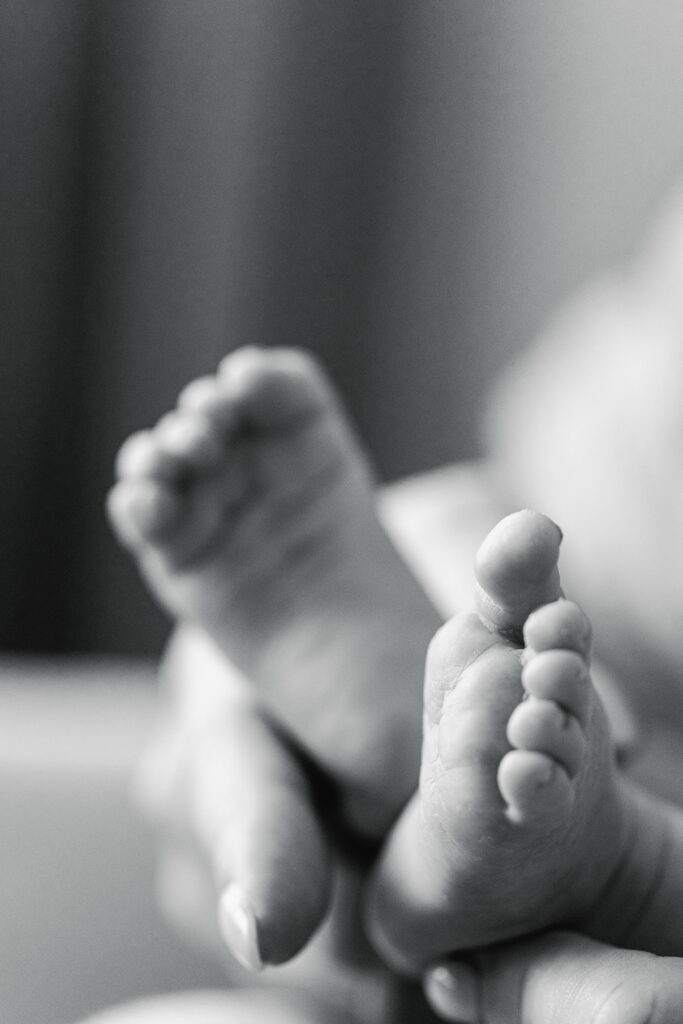 Close‑up of newborn’s tiny toes curled.