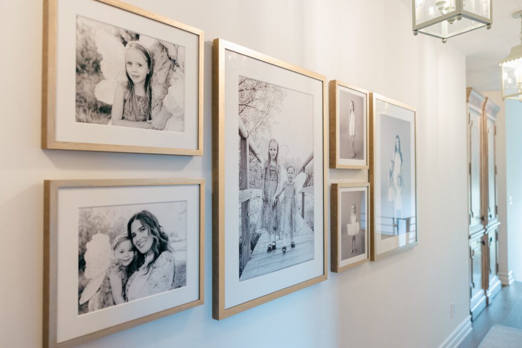 Angled view of full seven frame gallery wall with gold frames in Bend, Oregon hallway