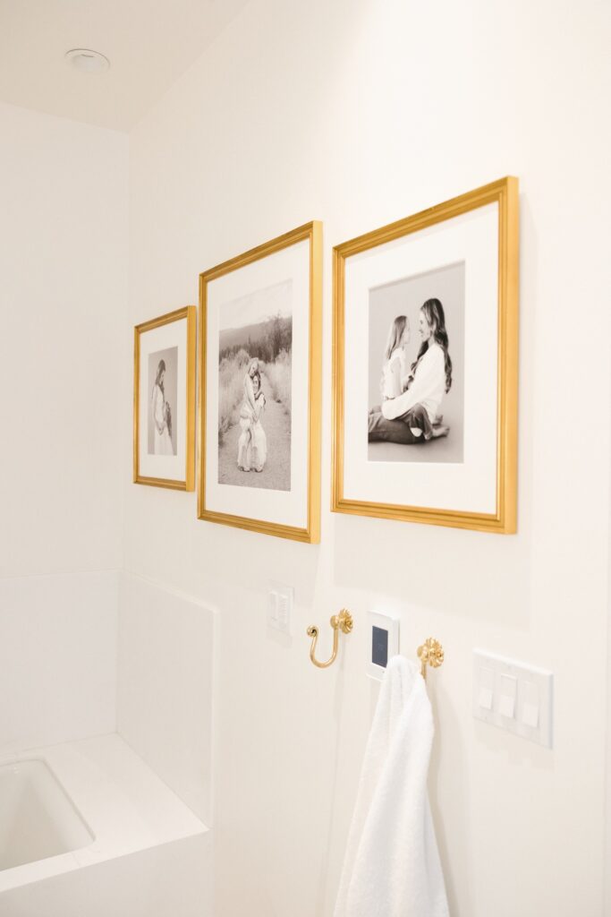 Black and white mother daughter portrait gallery in gold frames, bathroom wall art