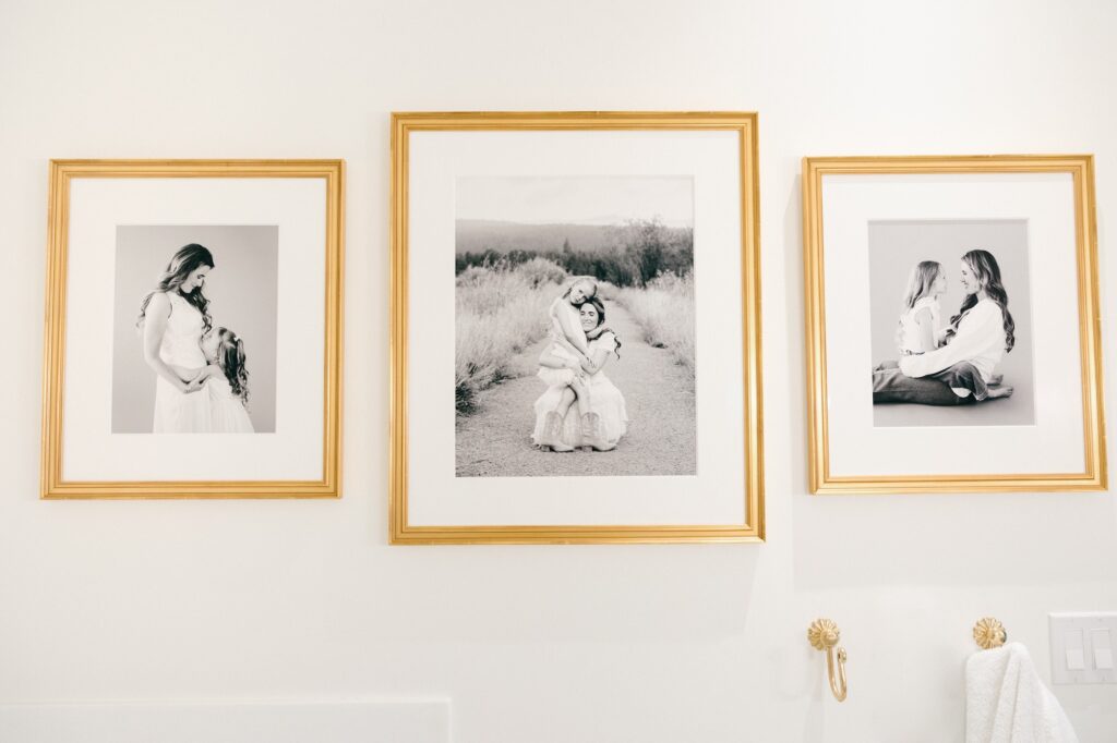 Black and white mother daughter portrait gallery in gold frames, bathroom wall art