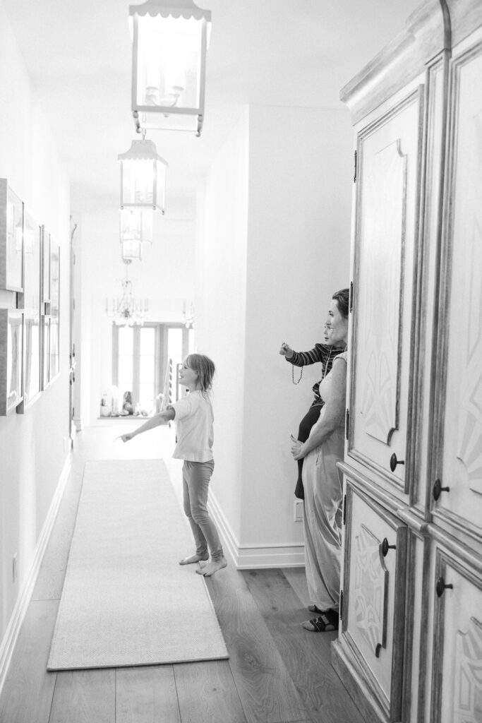 Daughters looking at custom framed portrait gallery wall in Bend, Oregon hallway