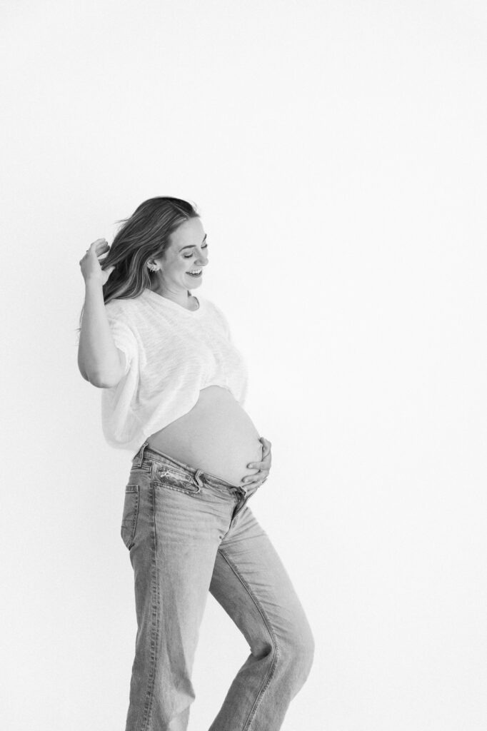 Simple maternity photography portrait featuring a white top and jeans